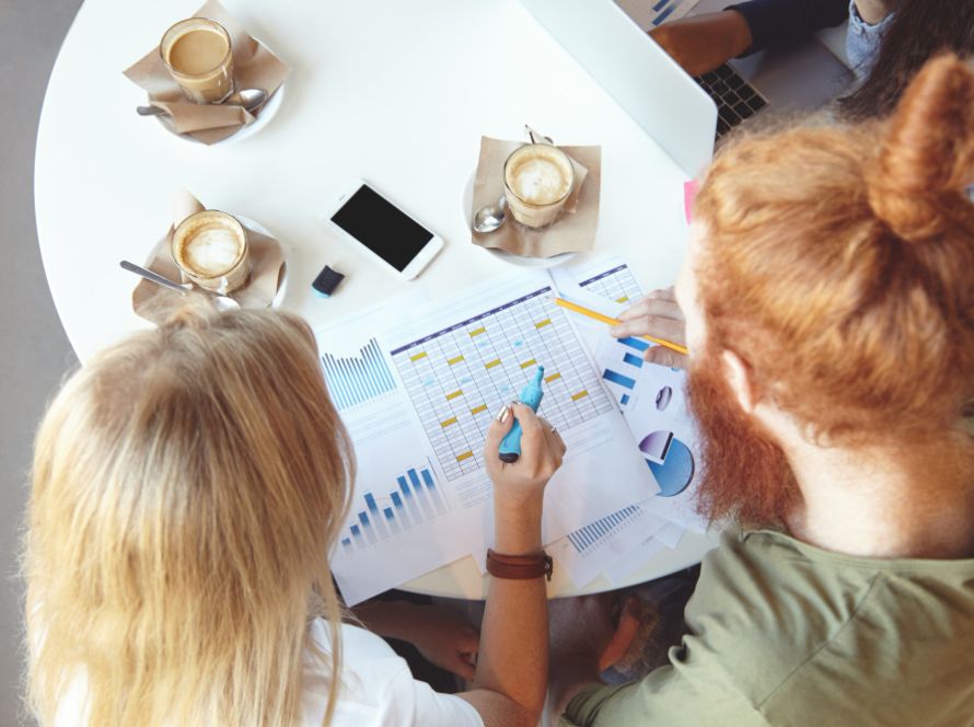 deux femmes calculant des taux de conversion sur un bureau